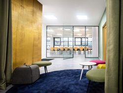 Moderner Lounge- und Meetingbereich mit Blick in einen Konferenzraum