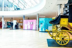 Eingangsbereich des Museums für Kommunikation mit alter gelber Postkutsche