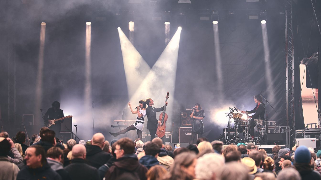 Band performing live on stage, audience enjoying.