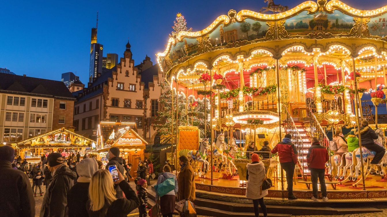 Beleuchtetes Karussell auf dem Weihnachtsmarkt am Abend.