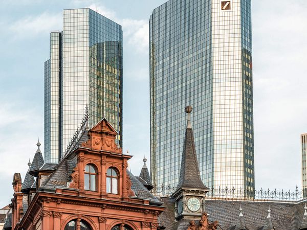 Historisches Gebäude vor moderner Hochhausfassade in Frankfurt.