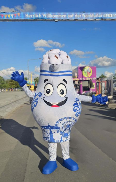 Ein blau-weißes Maskottchen auf dem Frankfurter Volksfest begrüßt Besucher.