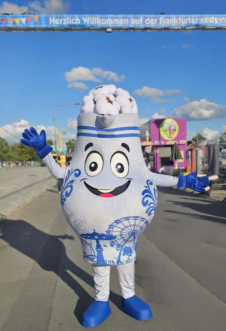 Ein blau-weißes Maskottchen auf dem Frankfurter Volksfest begrüßt Besucher.