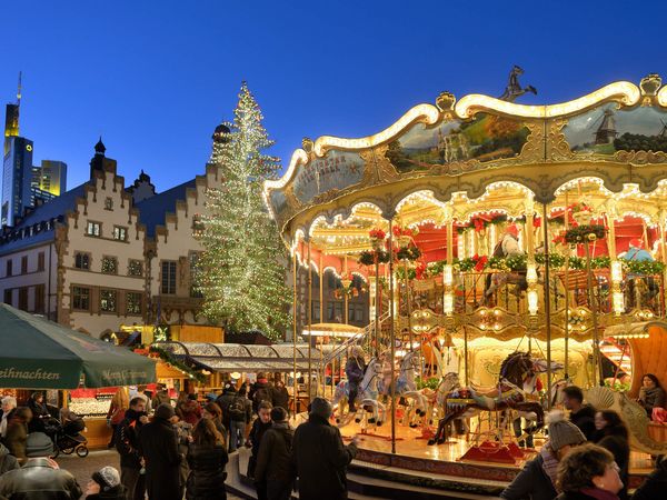Kinder fahren auf dem Karussell und Besucher genießen den Markt