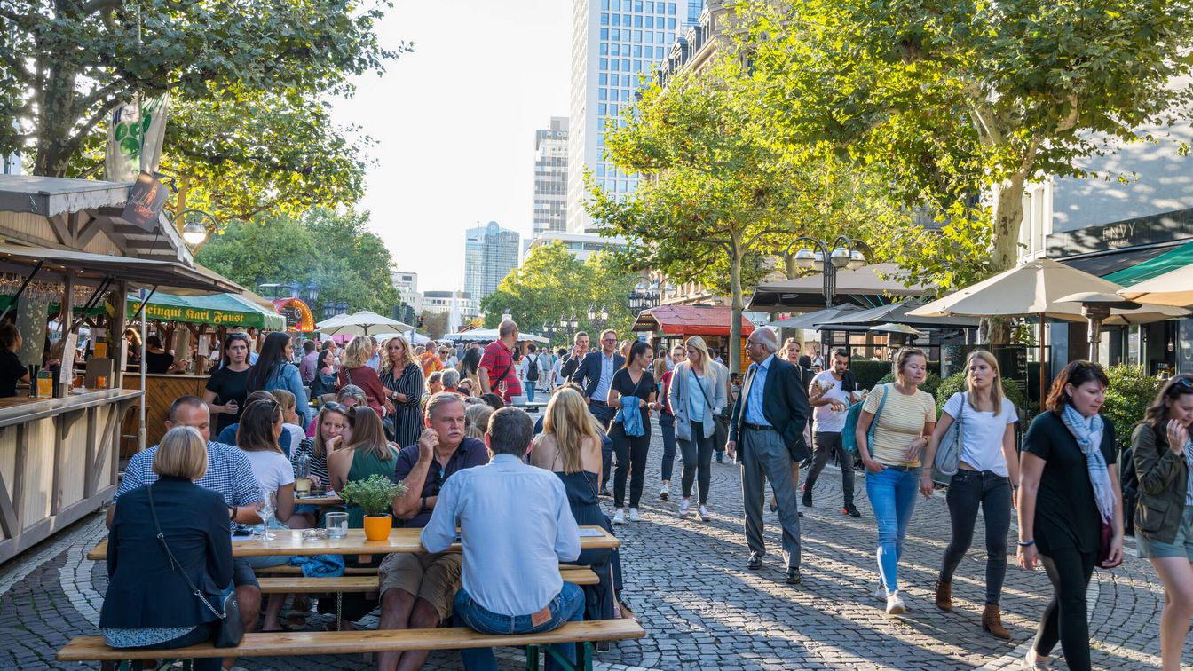 Besucher schlendern über den Rheingauer Weinmarkt und genießen den Wein und die Speisen vor Ort