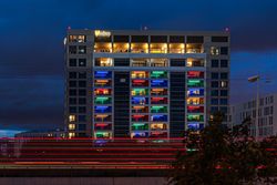 Beleuchtetes Gebäude im Dunkeln mit bunten Lichtern.