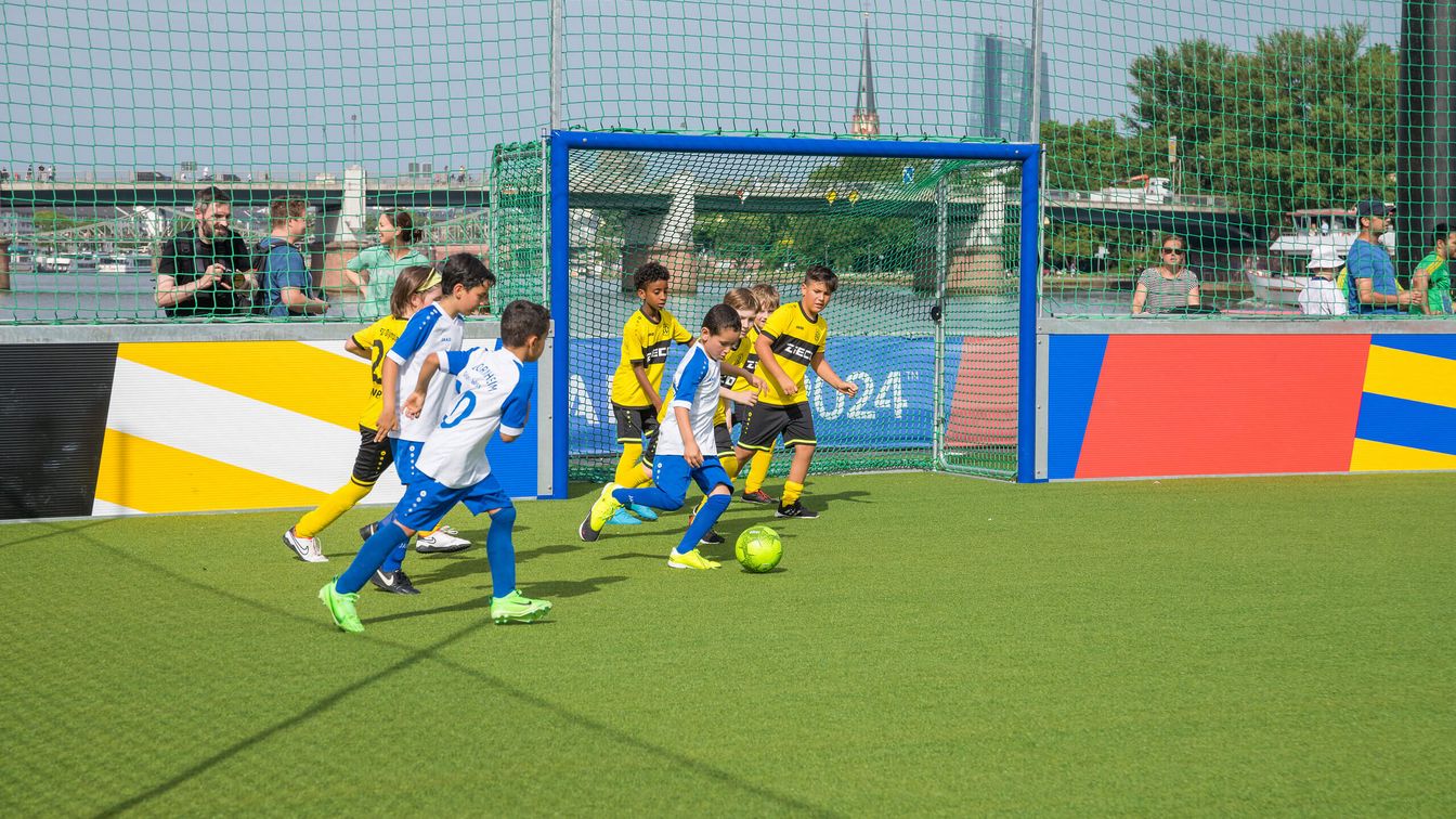 Kinderteams spielen auf dem schwimmenden Bolzplatz gegeneinander. 