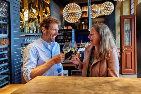 Couple toasting with wine glasses in wine bar