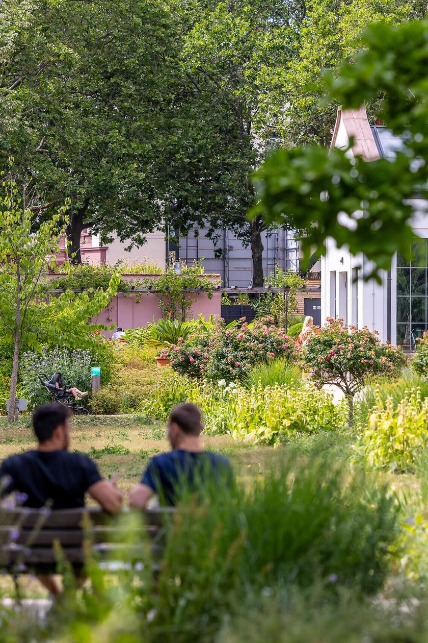 Ein idyllischer Blick in den Bethmannpark in Frankfurt, mit üppiger Vegetation, Sitzbänken und Spazierwegen. Menschen genießen die grüne Umgebung.