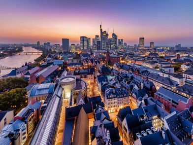 Blick vom Kaiserdom auf die Frankfurter Neue Altstadt, den Main und die Skyline in der Abenddämmerung.