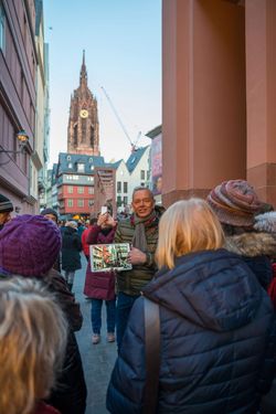 Gästeführer erzählt Gästen von der neuen Altstadt mit Blick auf den Kaiserdom