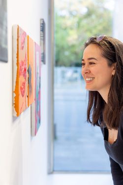 Eine Besucherin betrachtet in einer Galerie ein Gemälde