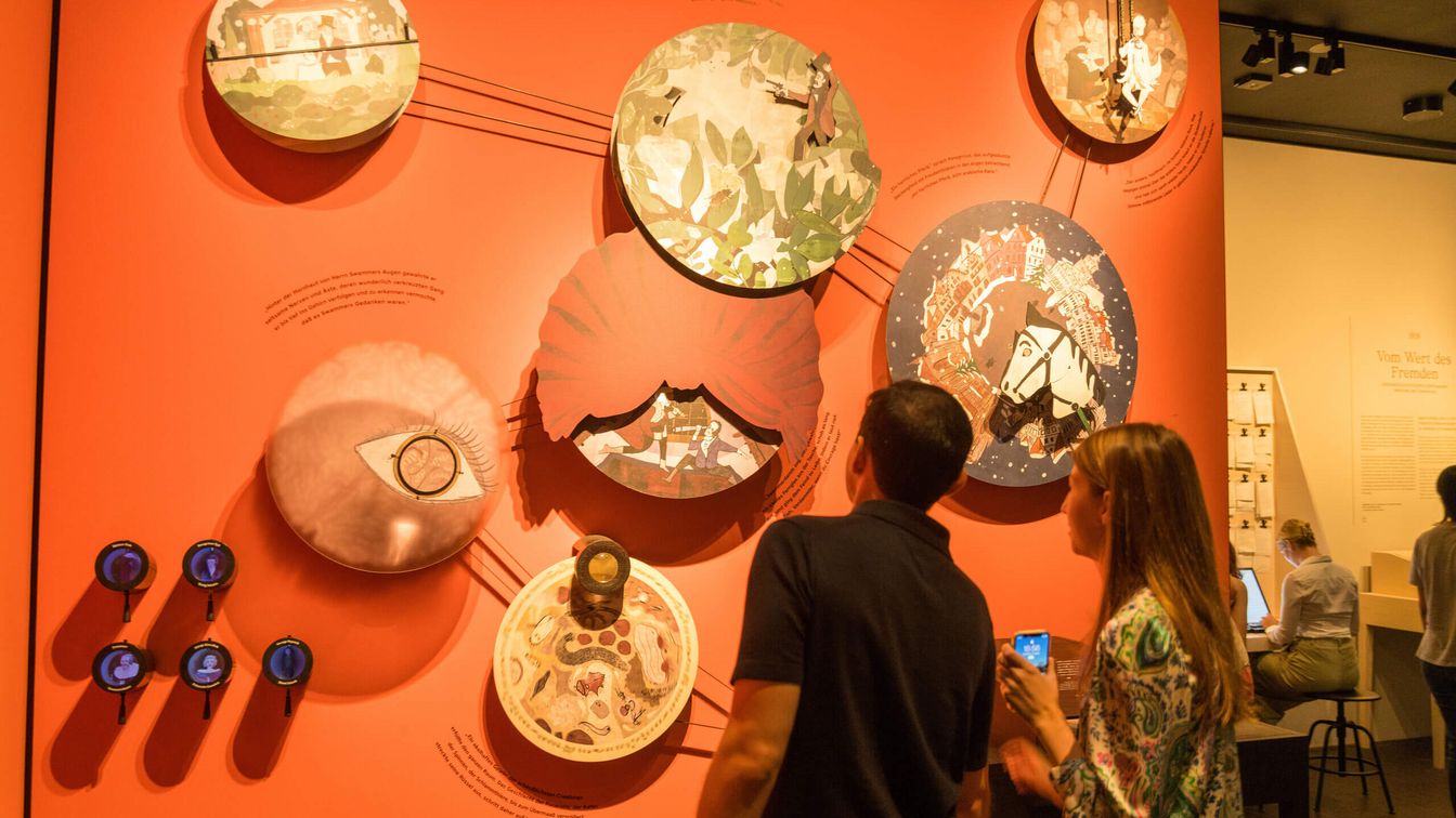 Besucher betrachten eine Installation aus Geschichten in einem Museum