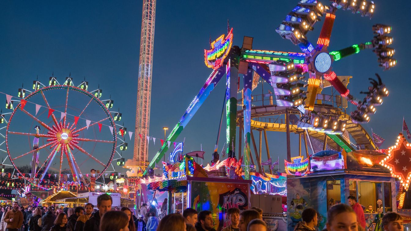 Das beleuchtete Riesenrad und Fahrgeschäfte der Dippemess