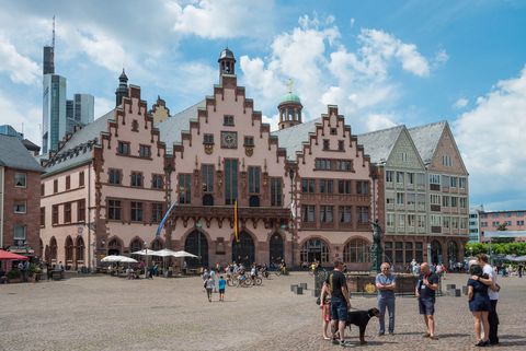 People on the Römerberg square in front of the Justitiabrunnen fountain and Römer city hall