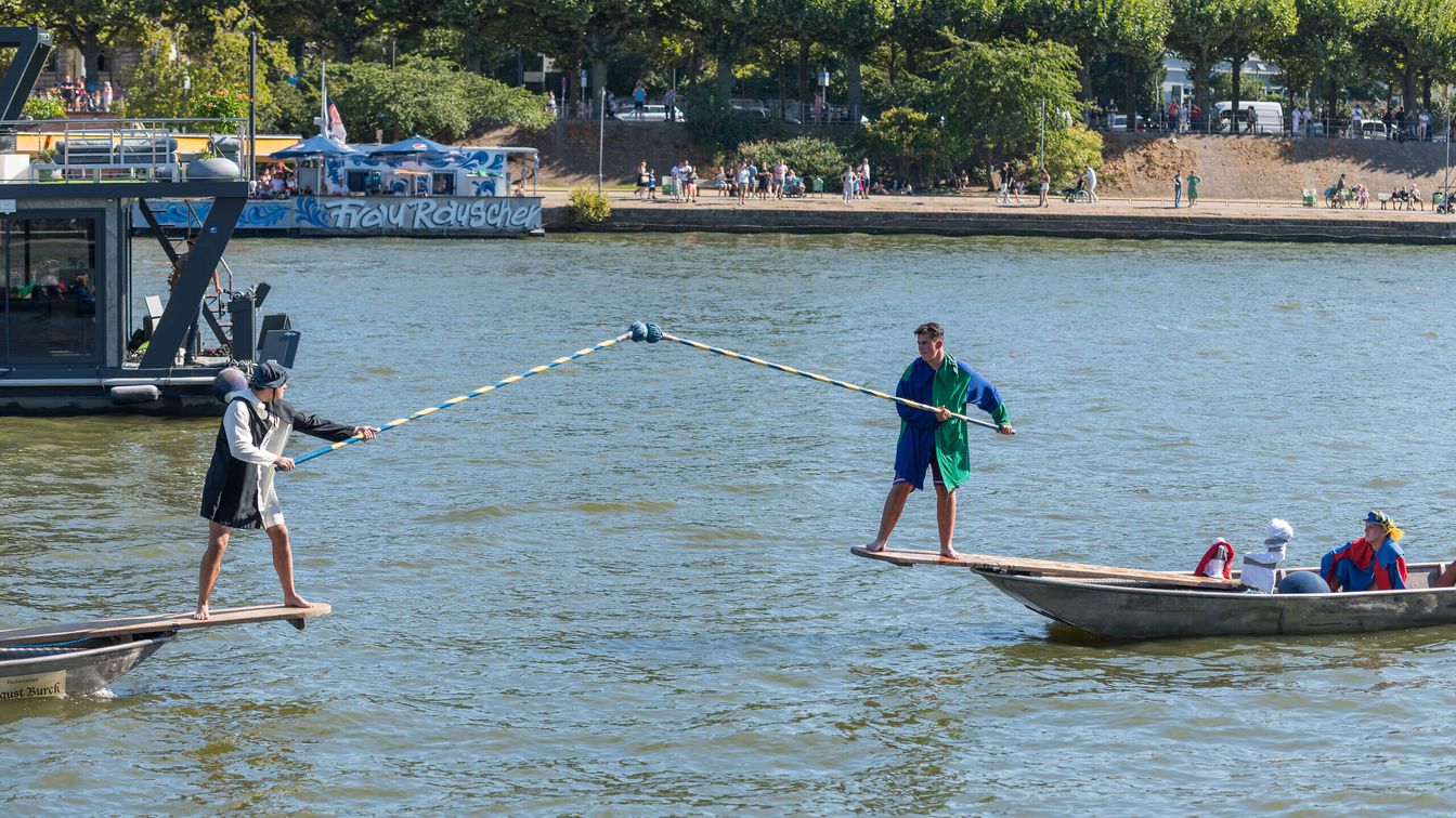 Fischerstecher*innen in Tracht mit Lanzen auf dem Main
