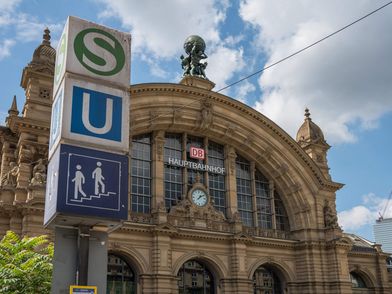 Ein Wegweiser zu U- und S-Bahnen steht vor dem in Neorenaissance-Stil erbauten Hauptbahnhof.