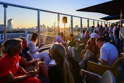 Weitläufige Rooftop-Terrasse mit Loungemöbeln und Sonnenschirmen