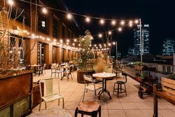 Rooftop-Terrasse bei Nacht mit Lichterketten und Skylineblick im Ruby Louise Hotel Frankfurt