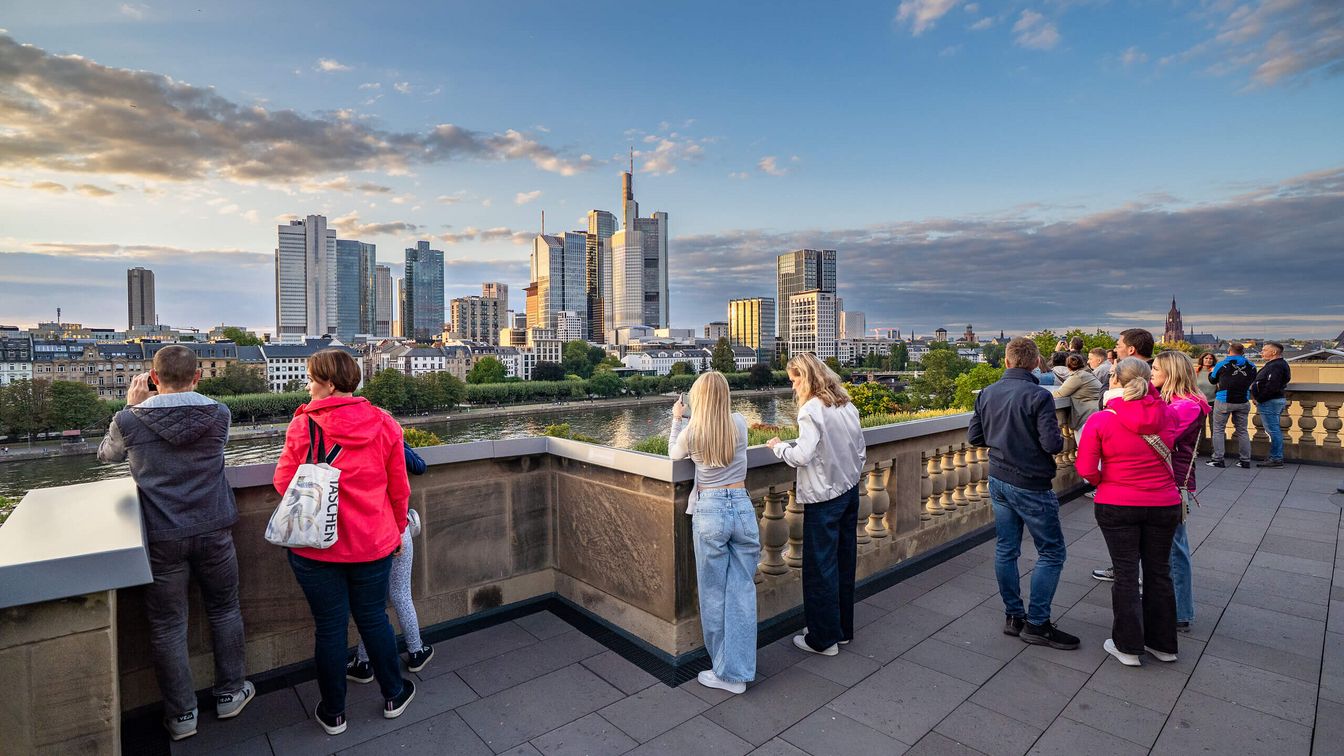Menschen genießen die Aussicht auf die Stadt von einer Terrasse. 