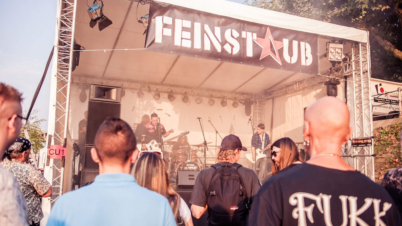 People stand in front of a stage. 