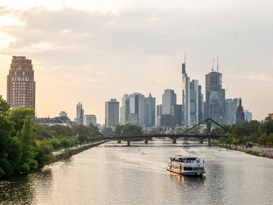 Boot auf dem Main mit Blick auf Frankfurts Skyline bei Abendlicht.