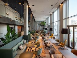 Moderne Hotellobby mit großen Fenstern, Designmöbeln und Pflanzen im b'mine Hotel Frankfurt