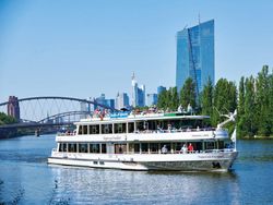 Schiff der Primus Linie auf dem Main mit der Frankfurter Skyline und blauem Himmel im Hintergrund.