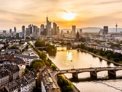 Sonnenuntergang über dem Main mit Skyline und Brücke in Frankfurt.