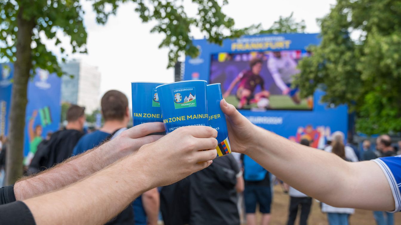 Gäste der Fan Zone stoßen miteinander an. 