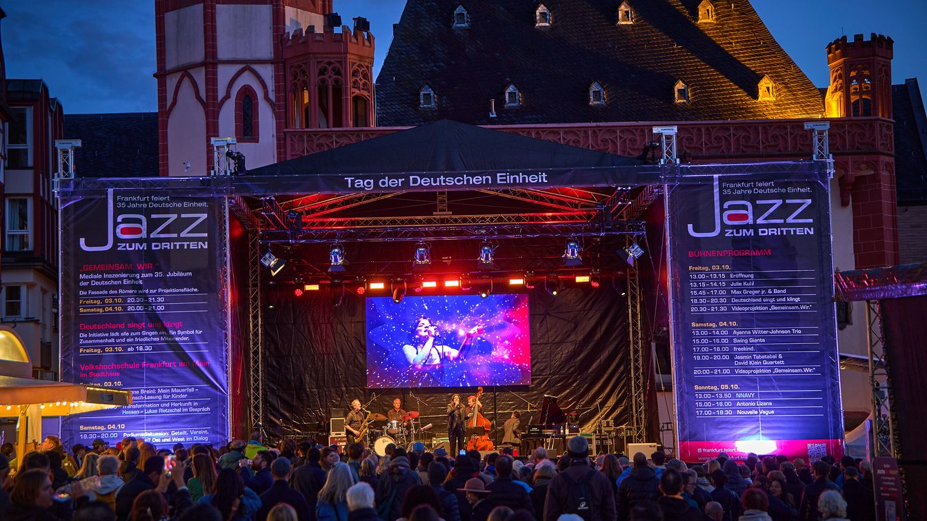 Concert stage and crowd in historic square at night